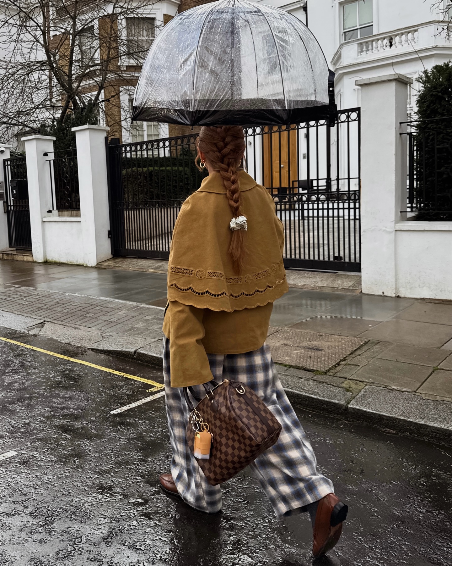 Rebecca Ferrazwyatt walking in the rain wearing checked trousers