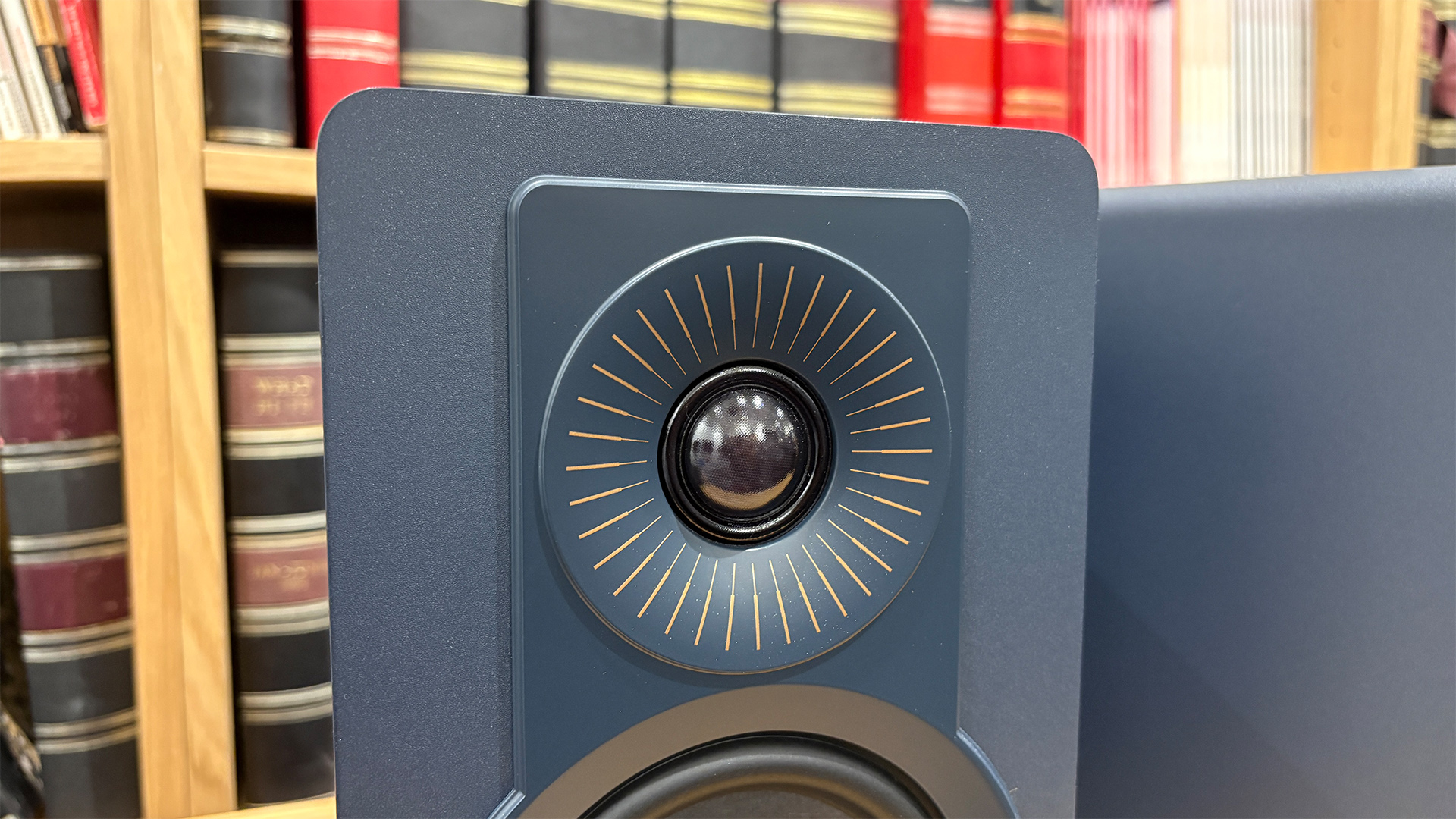 Dali Kupid standmount speakers in front of bookcase, detail of tweeter
