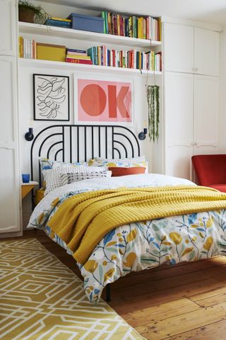 Colorful retro inspired, fun bedroom with built-in shelving above bed for books, and sculptural headboard.