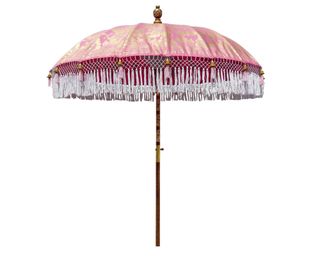 A pink patterned garden parasol with fringing detail