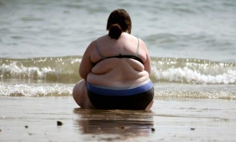 A woman sits at the water&amp;#039;s edge in Bournemouth, England