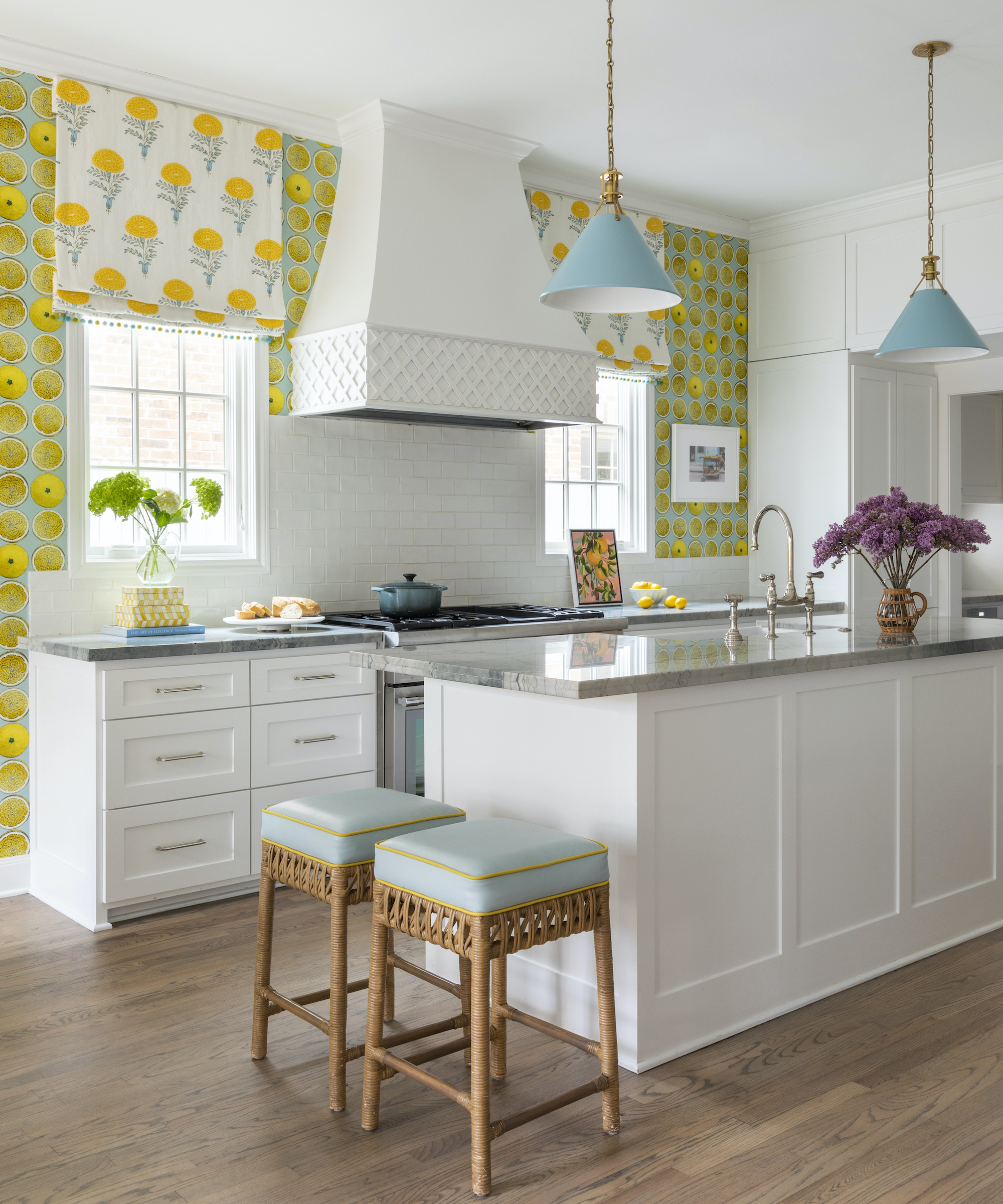 white kitchen island with lemon wallpaper and marigold print blinds behind