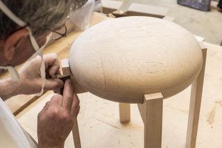 Craftsman working on a wooden stool