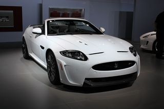 White Jaguar XKR-S sports convertible, grey tiled floor, white walls with wall art