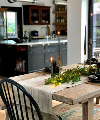 A reclaimed dining table in a kitchen diner with lit candles