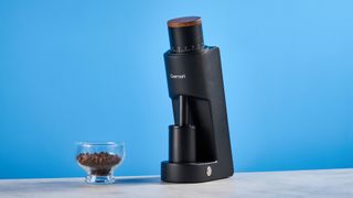 the wirsh geimori gu38 coffee grinder in black with a walnut hopper lid photographed against the blue tom's guide background