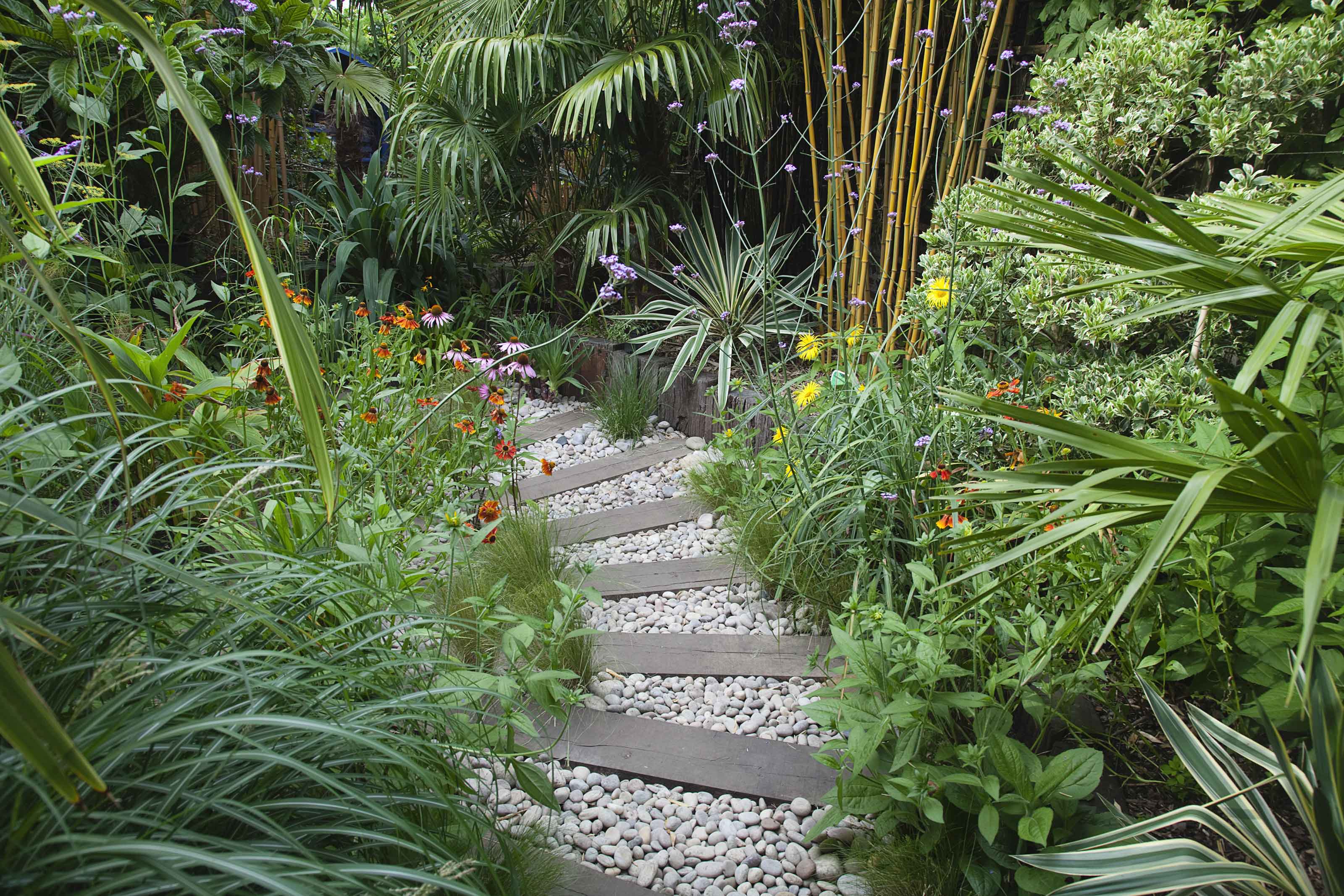 garden sleepers used as curved path with gravel and plants either side