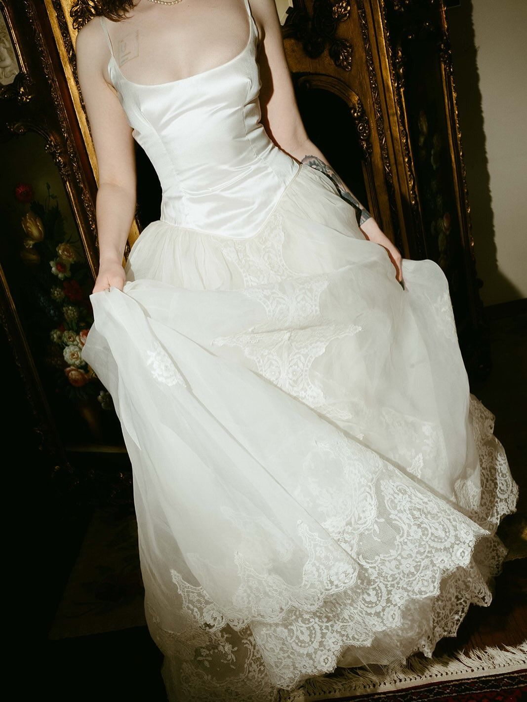 a woman wears a vintage bridal dress.
