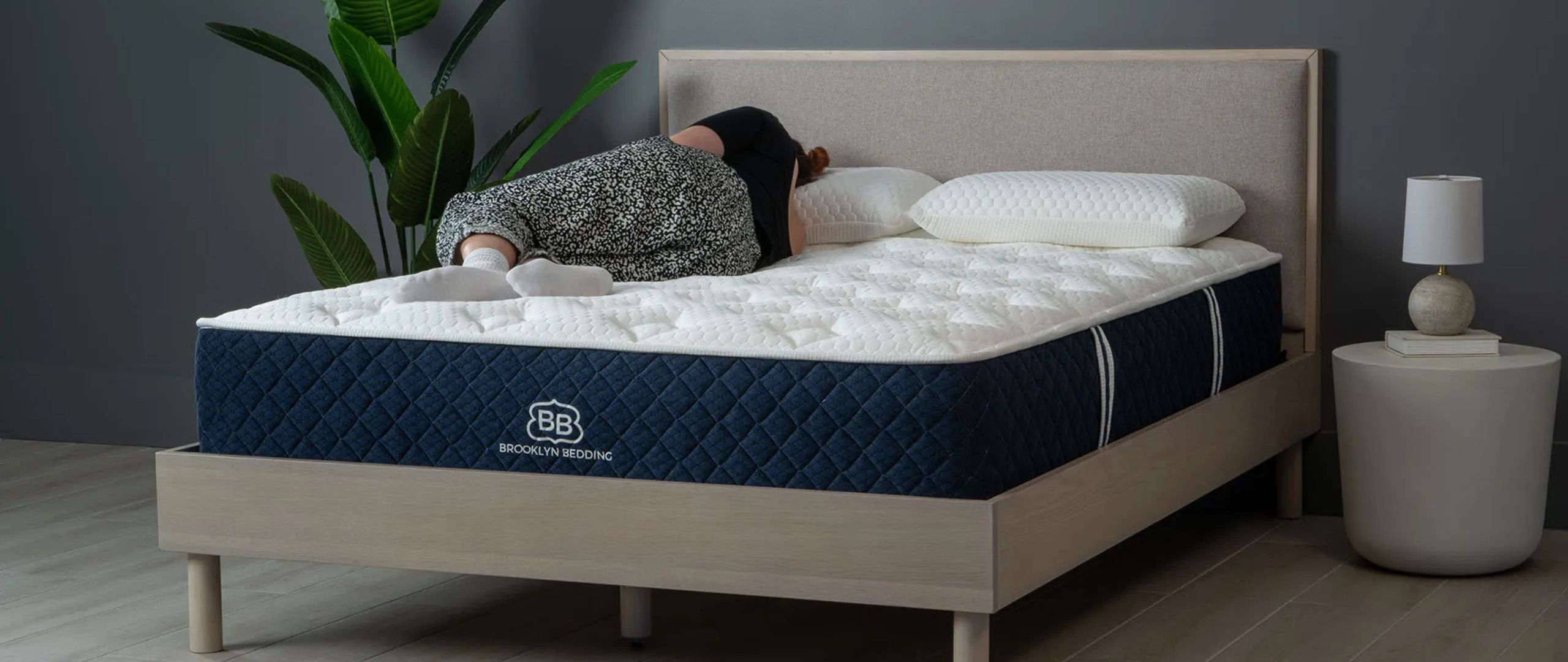 A woman sleeping on her side on the Brooklyn Bedding Signature Hybrid mattress in a minimalist bedroom