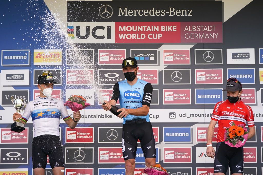 ALBSTADT GERMANY MAY 09 Victor Koretzky of France celebrates on podium whilst Nino Schurter of Switzerland and Mathias Flueckiger of Switzerland stand beside him on May 09 2021 in Albstadt Germany Photo by Christian KasparBartkeGetty Images