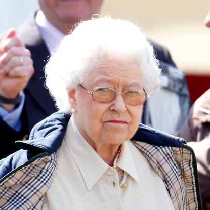 Queen Elizabeth II has pursed lips and white hair and looks very annoyed