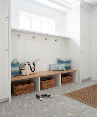 A mudroom with benches and storage with wall hooks and cushions - Merinda Studio
