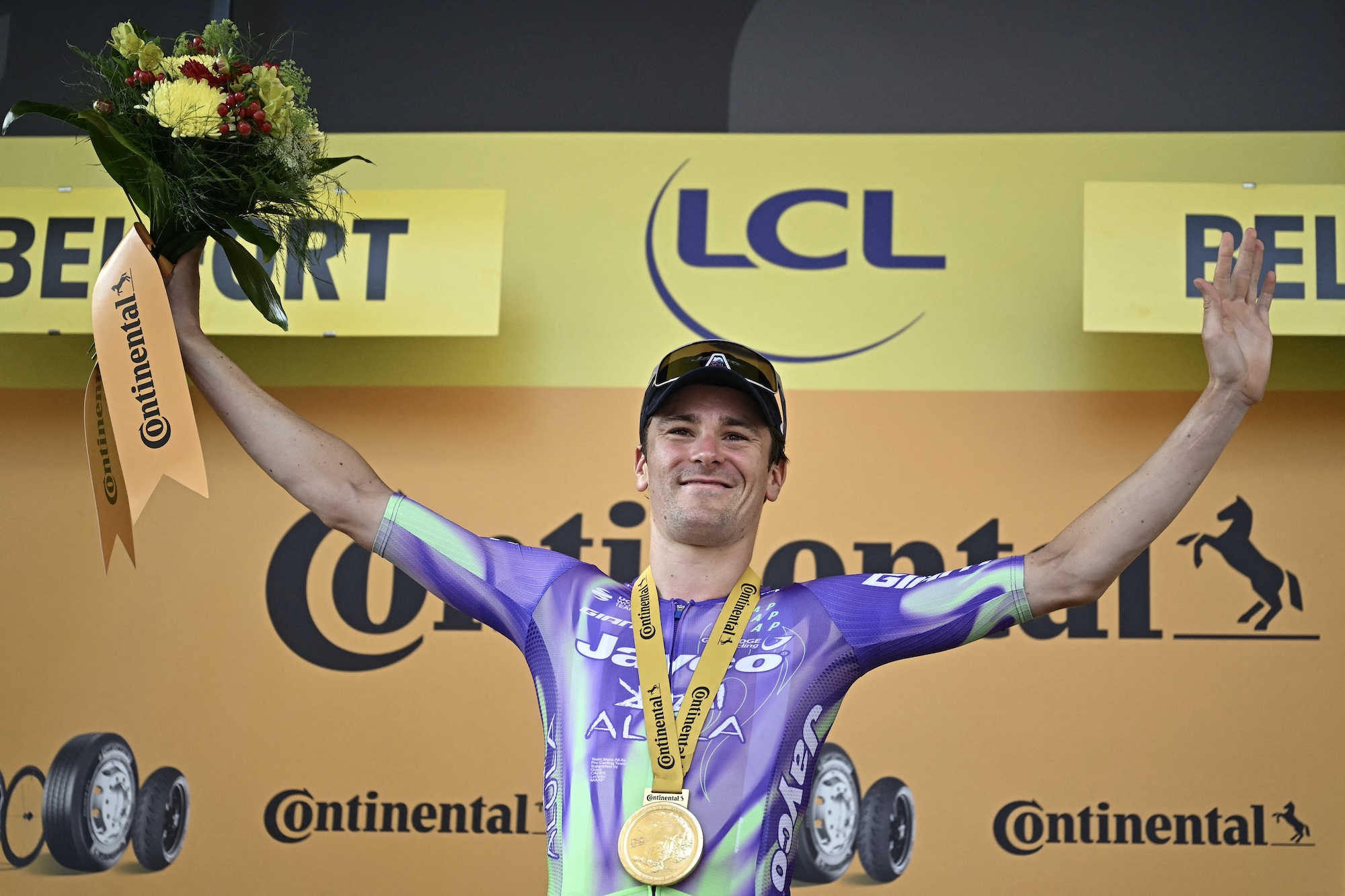 Mauro Schmid celebrates on the podium after winning the 13th stage of the 113th edition of the Tour de France 