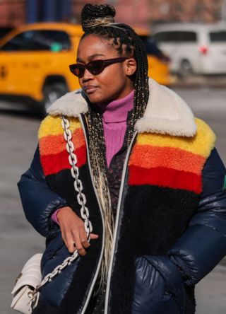 A woman in New York wearing a colourful boucle jacket with padded sleeves.