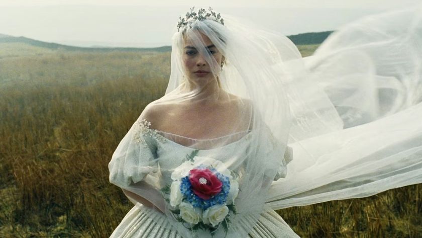 Cathy in a wedding dress and veil crossing the moors