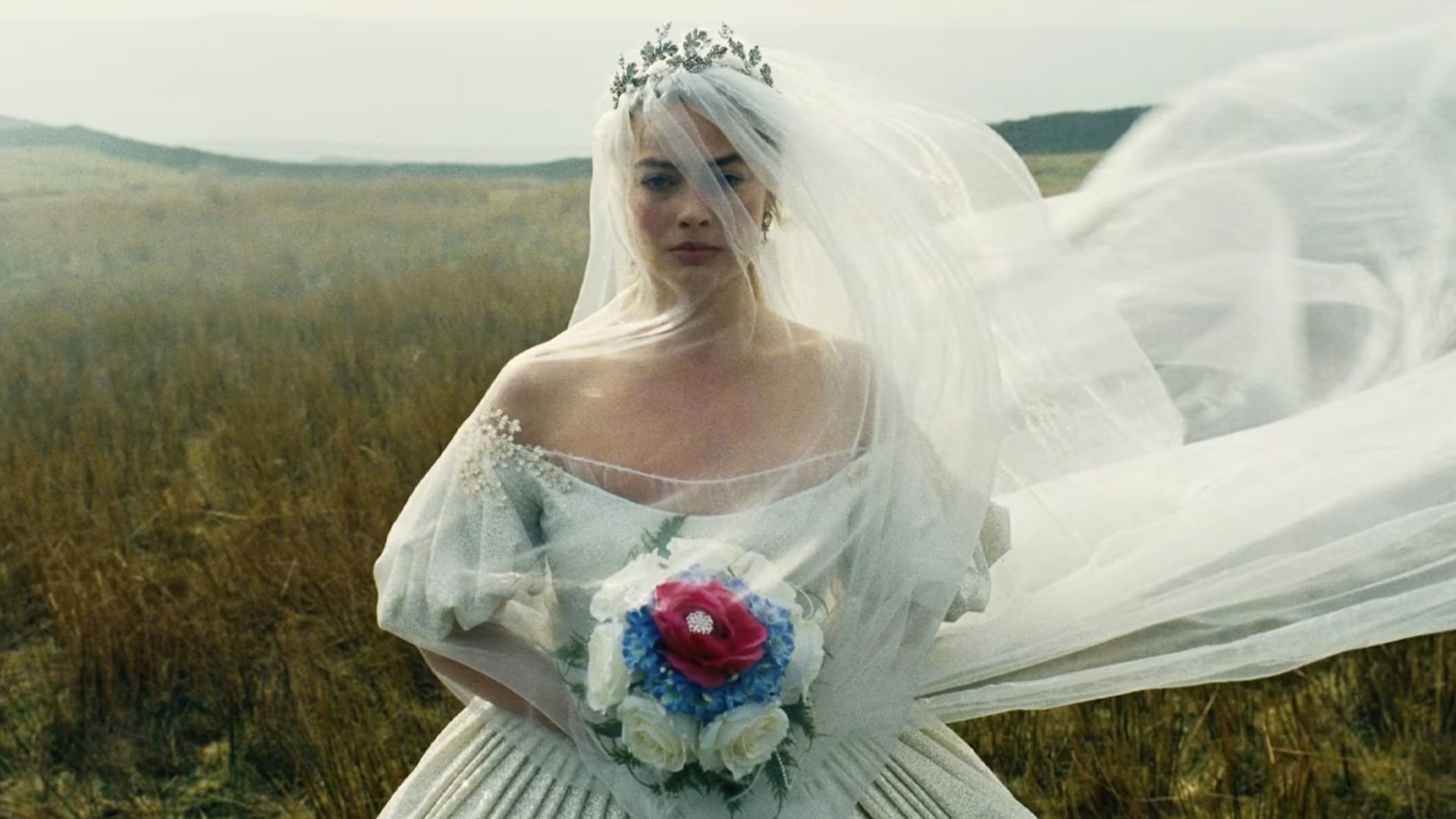 Cathy in a wedding dress and veil crossing the moors