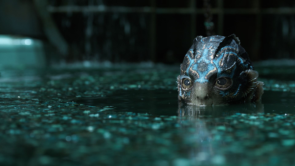 A still from the movie The Shape of Water in which the amphibian creature peaks up from beneath the water.