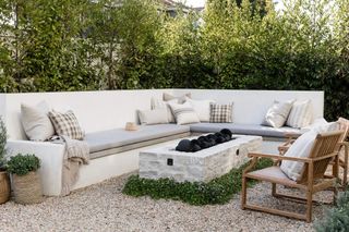 a large cream corner bench on a patio with a firepit