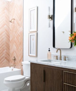 A bathroom with peach pink tiles in the shower