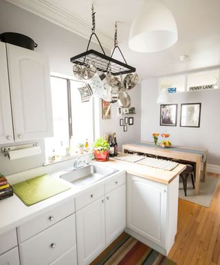 small white kitchen with homemade pot hanging rack