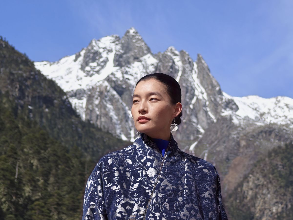 Portrait of a woman in a shawl in front of snowy mountains