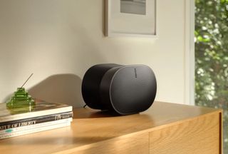 The Sonos Era 300 in black pictured on a wooden cabinet