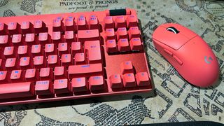 En rosa Logitech G Pro X Superlight 2 ligger bredvid ett matchande tangentbord.