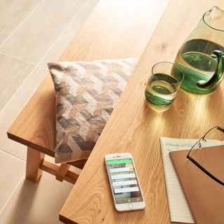 notebook on table with smart phone and juice jar with glass