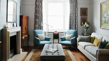 Living room with blue armchairs, grey sofa and modern fireplace