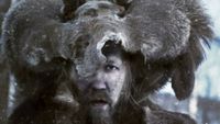 A man with a fur animal hat in the snow