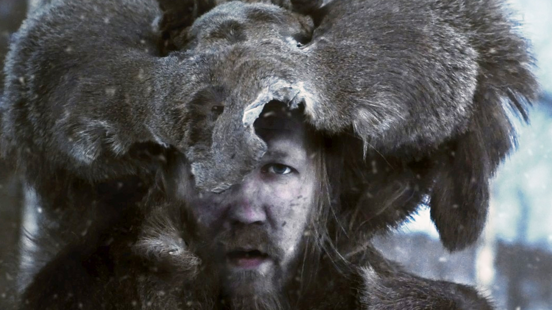 A man with a fur animal hat in the snow