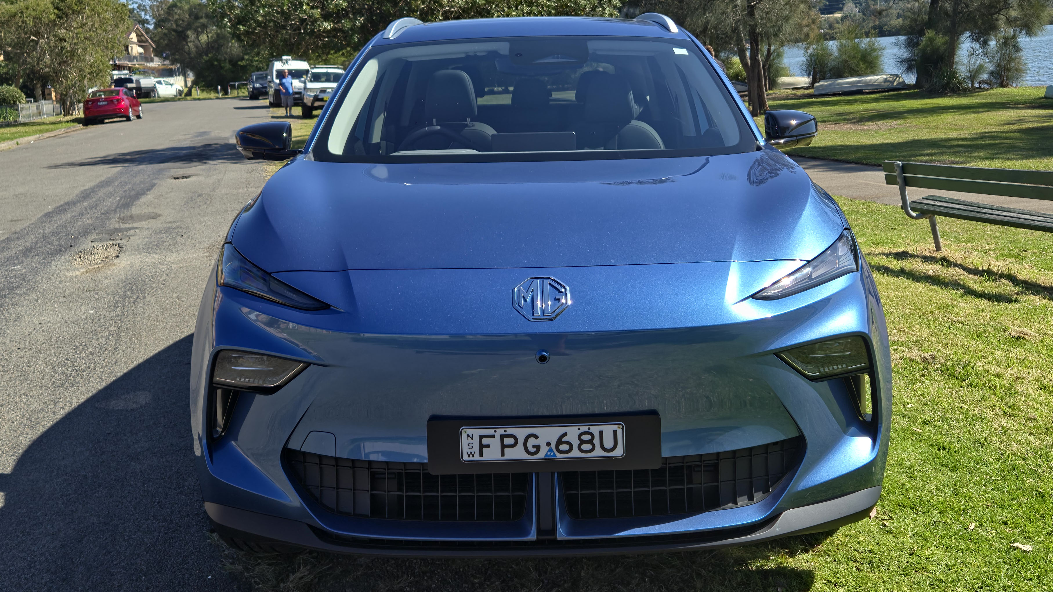 The MG S5 parked on grass in a park near a suburban neighbourhood