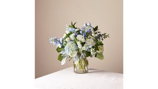 A bouquet of blue delphiniums, hydrangeas, and white roses, for the best flower delivery services.