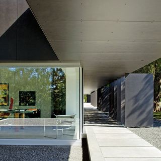 charcoal coloured house with translucent acrylic panels and white pathway