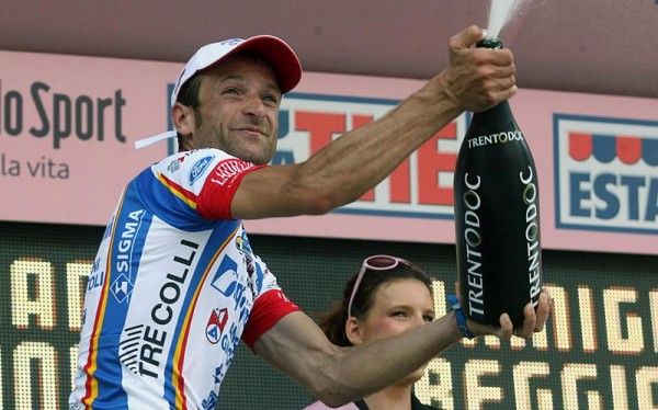 Stage winner Michele Scarponi uncorks the bubby on the podium.