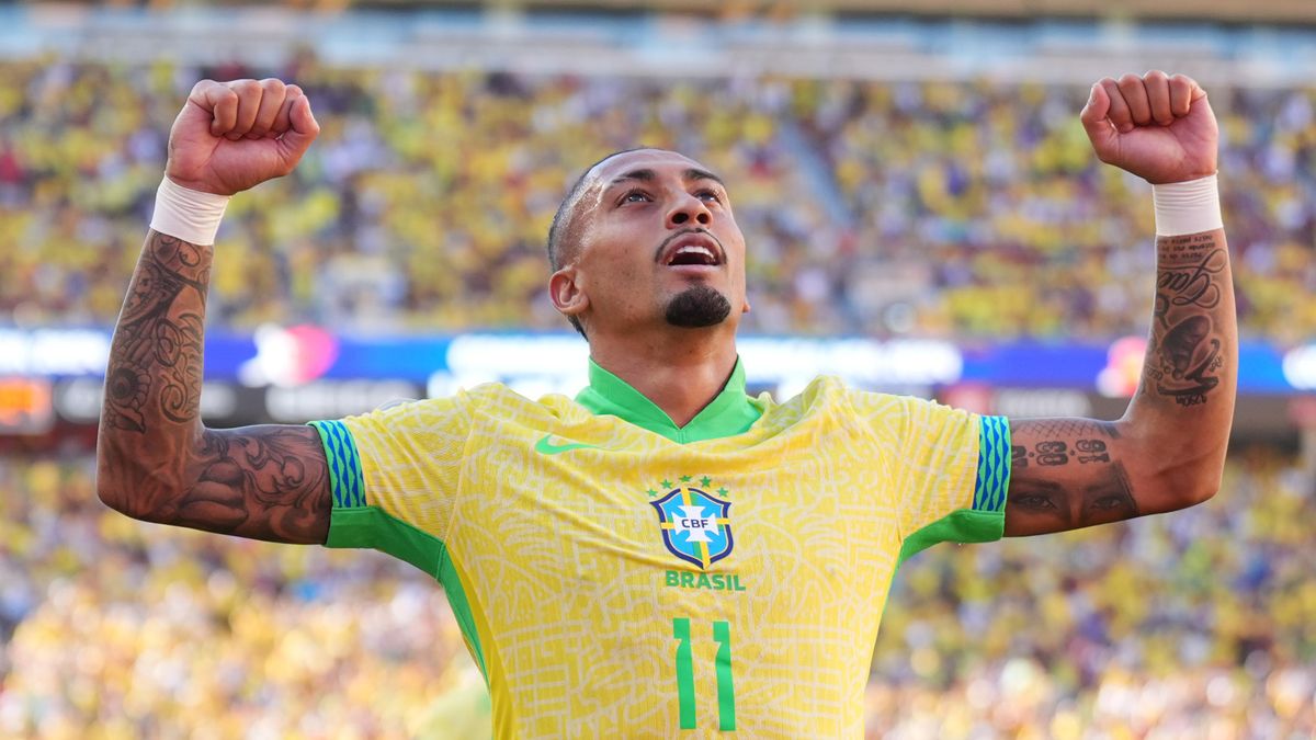 Raphinha celebrates a goal ahead of the Brazil vs Ecuador live stream in a yellow Brazil shirt.