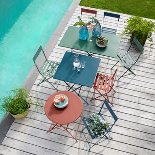 sets of coloured garden furniture on a decked terrace