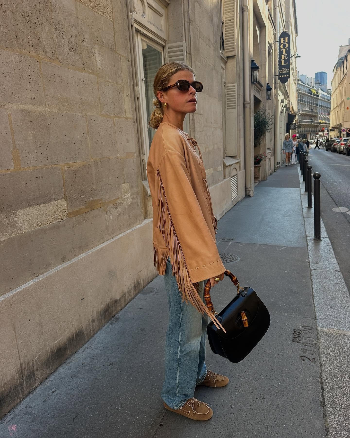 @alicepilate wearing a fringe jacket, Gucci bag, and jeans.