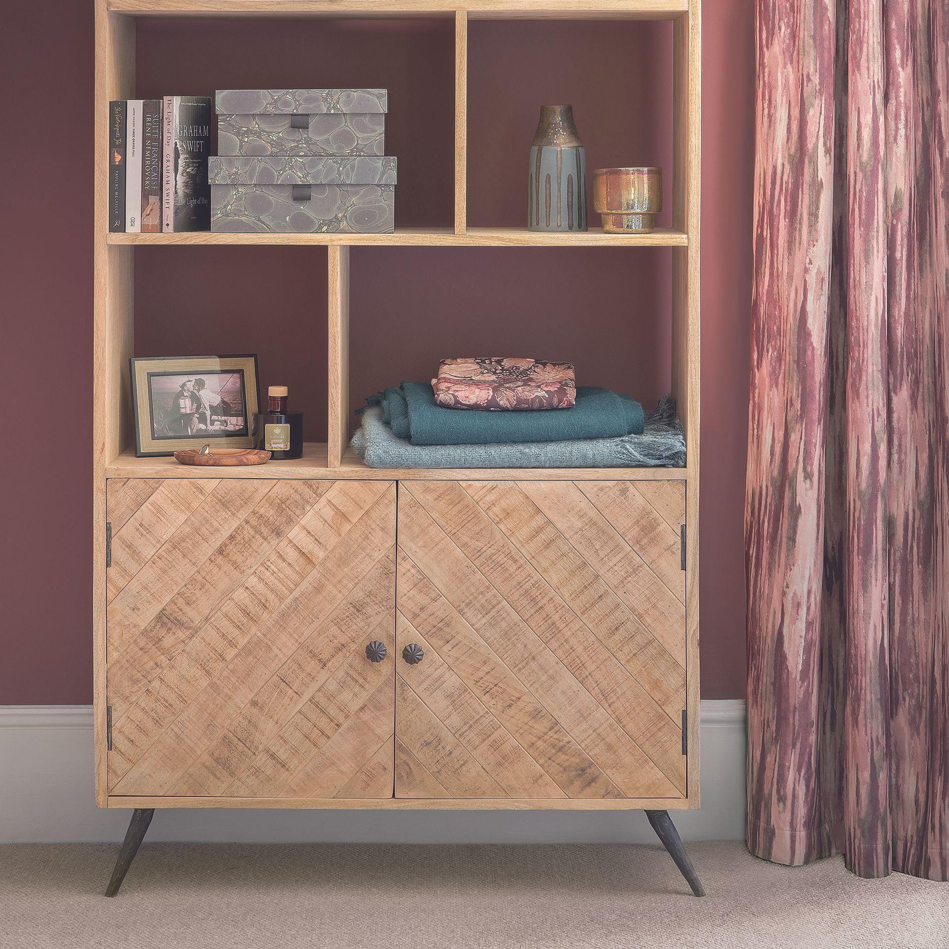 Living room with wooden shelving unit decorated with accessories.