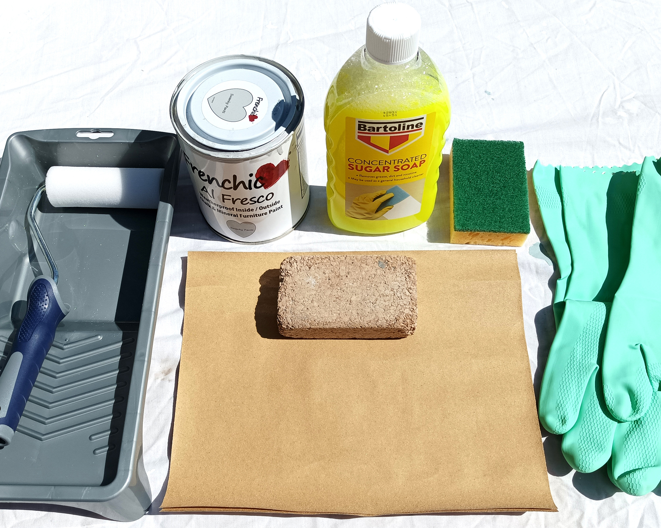 tools required for painting gloss kitchens, including sugar soap, paint, roller and sanding block