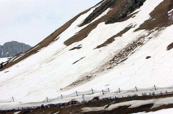 The peloton descends through the wintery landscape of Passo Rolle.