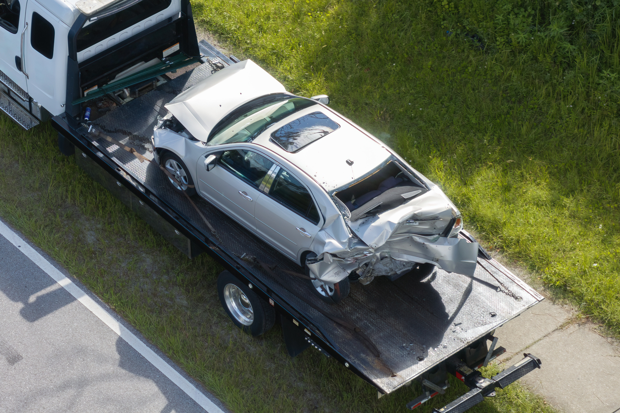 A tow truck hauls a seriously damaged car after a car accident.