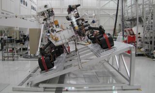 The image shows Curiosity on a tilt table in the Spacecraft Assembly Facility at NASA's Jet Propulsion Laboratory, Pasadena, California.
