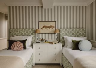 A twin bedroom with stripey wallpaper
