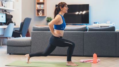 Woman performs lunges during a quiet home workout