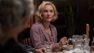 Michelle Randolph as Elizabeth sitting at the table with a utensil in her right hand in 1923. 