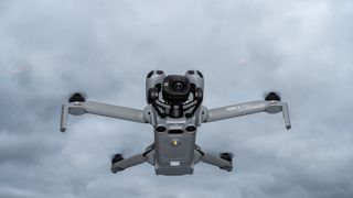 DJI Mini 5 Pro in flight against a cloudy sky