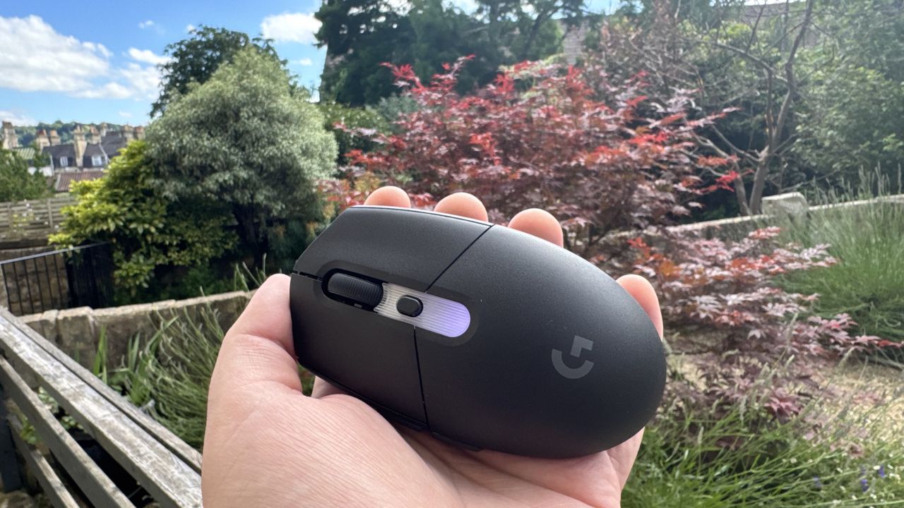 Logitech G305 X Superlight gaming mouse, held in a hand outside