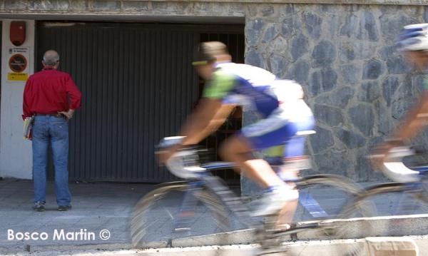 Riders pass by the garage where Xavier Tondo was killed