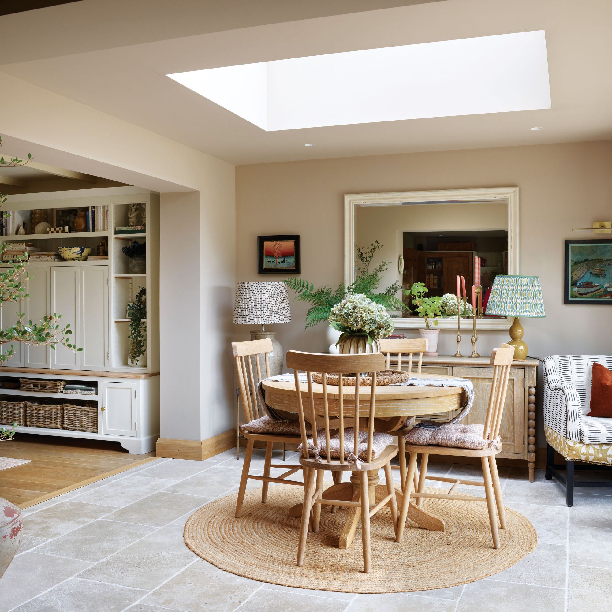 Dining room with concrete floor tiles, jute rug and wooden table and chairs